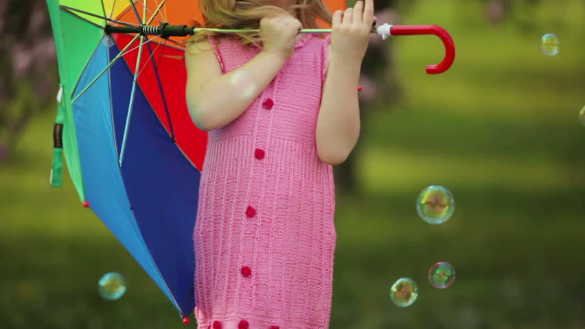 Cute child with umbrella in the garden
