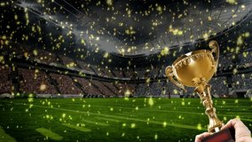 Field of stadium with bright spotlights. View of an football stadium with Confetti falling and Hands Holding a Golden Trophy. - Powered by Shutterstock - Get 15% off with code: PIKWIZARD15