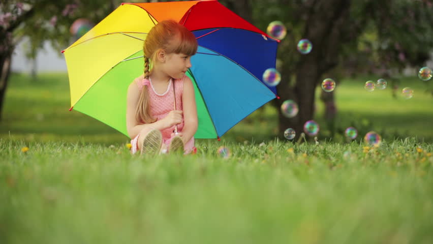 Cute girl with colorful umbrella smiling
