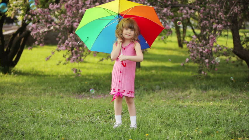 Kid turnning the umbrella and smiling
