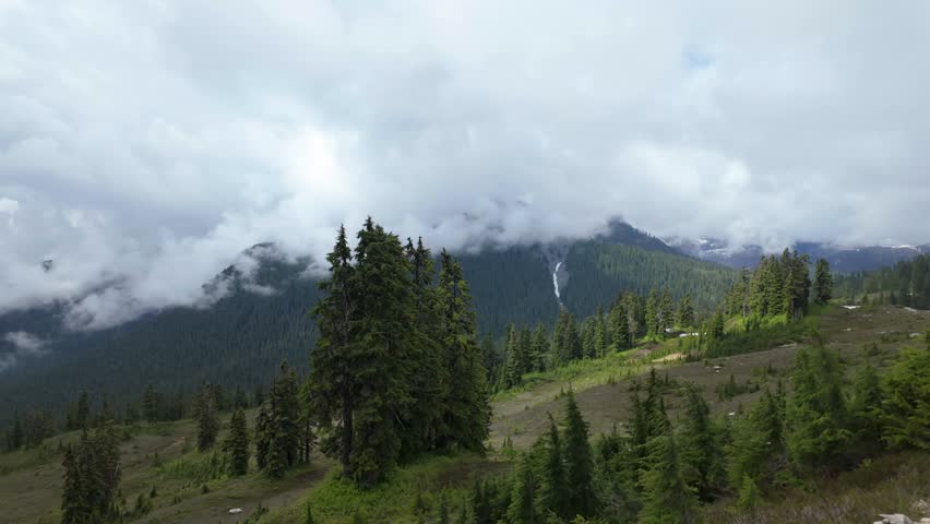 Majestic Mountain Landscape with Lush Green Forests and Dramatic Clouds in British Columbia, Canada.