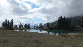 Stunning Mountain Lake Reflecting Sky and Clouds Amidst Lush Evergreen Trees in British Columbia, Canada. - Powered by Shutterstock - Get 15% off with code: PIKWIZARD15