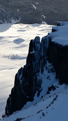Stunning Winter Landscape: Snow-Covered Mountains, Icy Cliffs, and Pristine Wilderness in British Columbia, Canada
