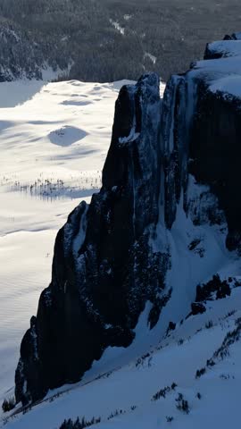Stunning Snowy Scenery of Canadian Rockies with Ice-Covered Rock Formations and Vast Plains.