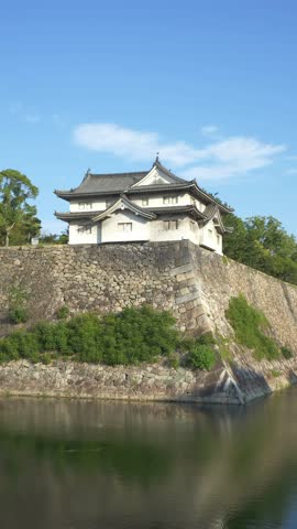 Vertical View Of Two-Level Sengan Yagura Turret Atop Ishigaki Stone Walls And Moat Within Osaka Castle Park, Japan. Static Shot