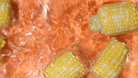 Fresh ears of corn falling into water splash in water top view slow motion. - Powered by Shutterstock - Get 15% off with code: PIKWIZARD15