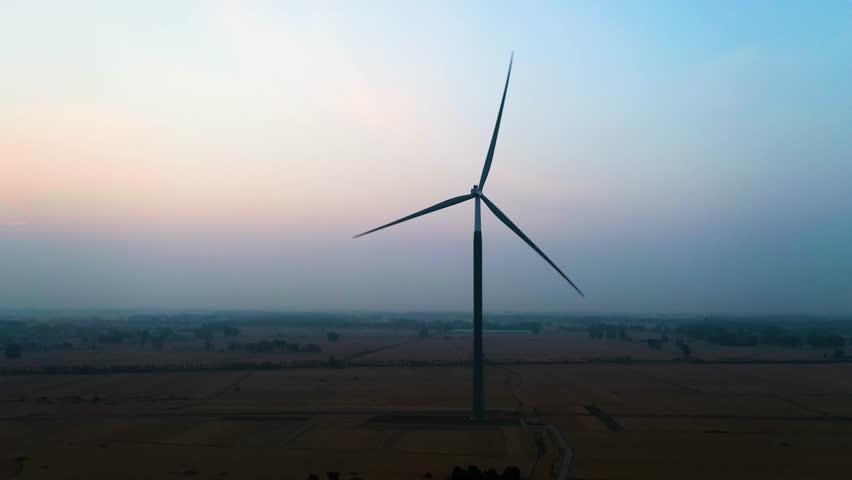Aerial: wind turbine at sunrise in Bozhou, Anhui province, China, orbit drone shot