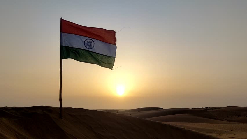 Waving Indian flag on the sand dune with beautiful sunrise view