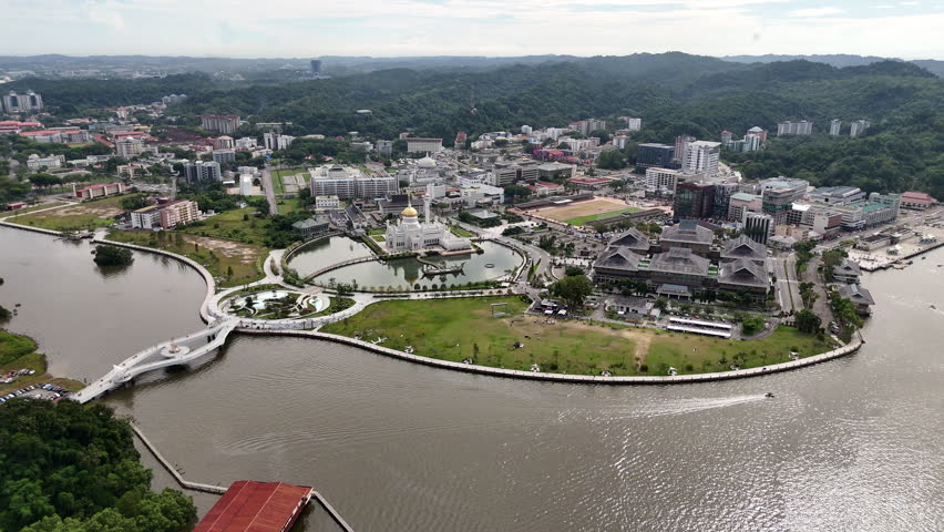 Rotating aerial drone shot of the town, river, and the Omar Ali Saifuddien Mosque in Brunei.