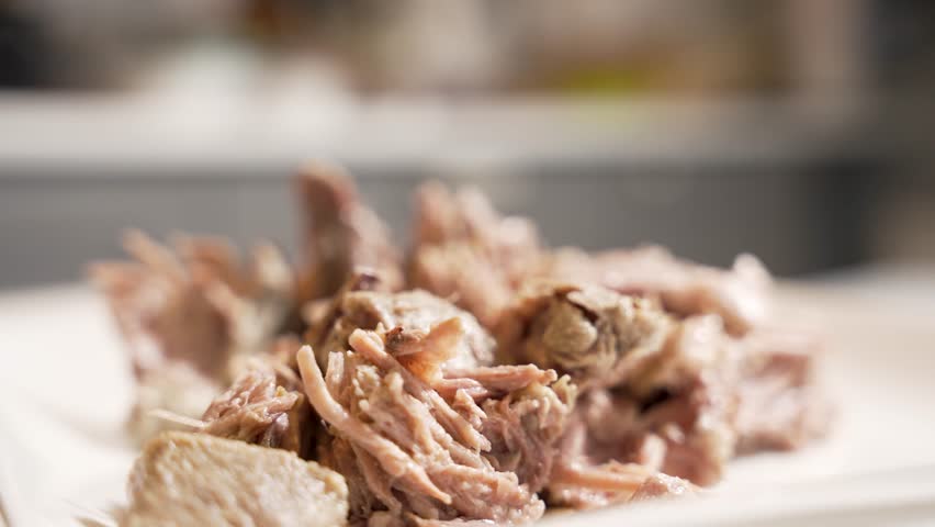 Tender meat close-up. Close-up rotation of shredded cooked meat, showing juicy fibers and a fresh homemade texture. Ideal for cooking tutorials.