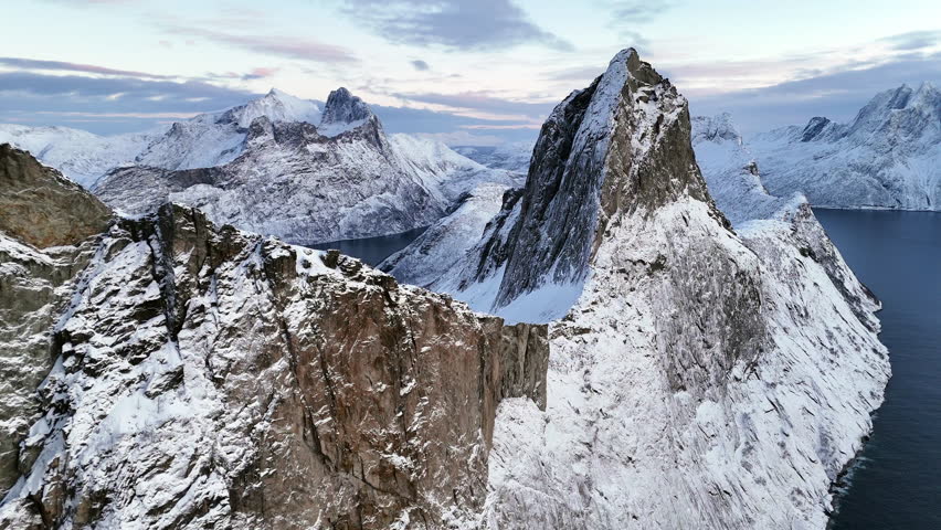 Cinematic aerial view of Hesten, one of the most photographed peaks on Senja Island, Norway, its horse-like shape towering over fjords and rugged Arctic landscapes in Troms og Finnmark County