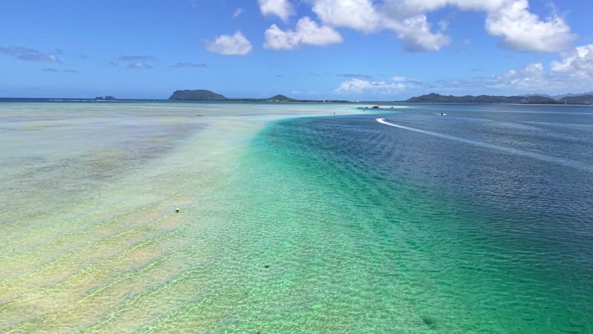Motorboat speeds through a channel next to the Kaneohe sandbar in Hawaii, Aerial