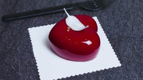 Heart shaped red mousse cake decorated with white chocolate shavings, gold leaf, sitting elegantly on lace doily with dark textured background, symbolizing romantic dessert - Powered by Shutterstock - Get 15% off with code: PIKWIZARD15