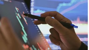 Close up of female hand touching stock market analysis digital display screen, analyzing investment and financial trading data in candlestick chart on a touch screen interface. Business and finance. - Powered by Shutterstock - Get 15% off with code: PIKWIZARD15