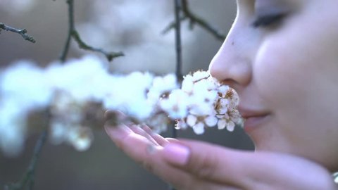 beautiful women smelling white flowers in springtime outdoors close up 1080