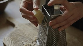 Grating hard cheese on metal kitchen grater. - Powered by Shutterstock - Get 15% off with code: PIKWIZARD15