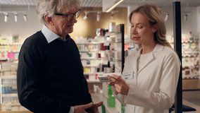 Old senior man customer buying cardiac pills in pharmacy medical help woman doctor caregiver pharmacist consult patient medicine vitamins drugs heart disease health care professional recommendation - Powered by Shutterstock - Get 15% off with code: PIKWIZARD15