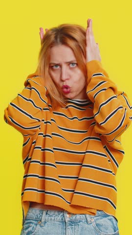 Don't want to hear, listen. Frustrated annoyed irritated young blonde woman covering ears gesturing no, avoiding advice ignoring unpleasant noise loud voices. Girl isolated on yellow background