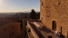 Drone aerial of Tuscan villa terrace set for luxurious outdoor dining. Vibrant floral centerpiece, elegant tableware, golden sunset light, perfect for upscale festive celebrations in Italy - Powered by Shutterstock - Get 15% off with code: PIKWIZARD15