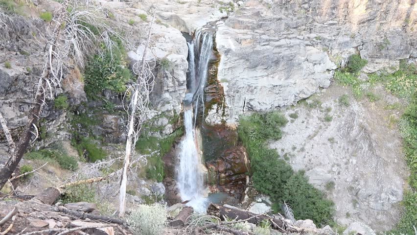 Mill Creek Falls cascading through a rocky canyon in Lassen Volcanic National Park, California, surrounded by forested mountain scenery.