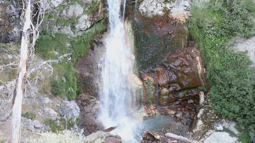 Lower section of Mill Creek Falls cascading through a rocky canyon in Lassen Volcanic National Park, California, surrounded by forested mountain scenery.
