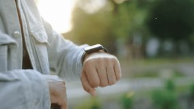 A close-up shot of a man's hand interacting with a smartwatch while outdoors, demonstrating the use of wearable technology for convenience and functionality.
 - Powered by Shutterstock - Get 15% off with code: PIKWIZARD15