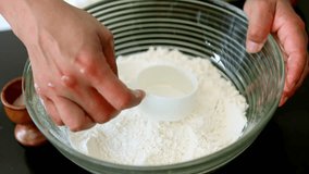Skilled baker forming classic flour well, carefully creating space for liquid ingredients while preparing homemade bread dough inside glass kitchen bowl for air fryer baking - Powered by Shutterstock - Get 15% off with code: PIKWIZARD15