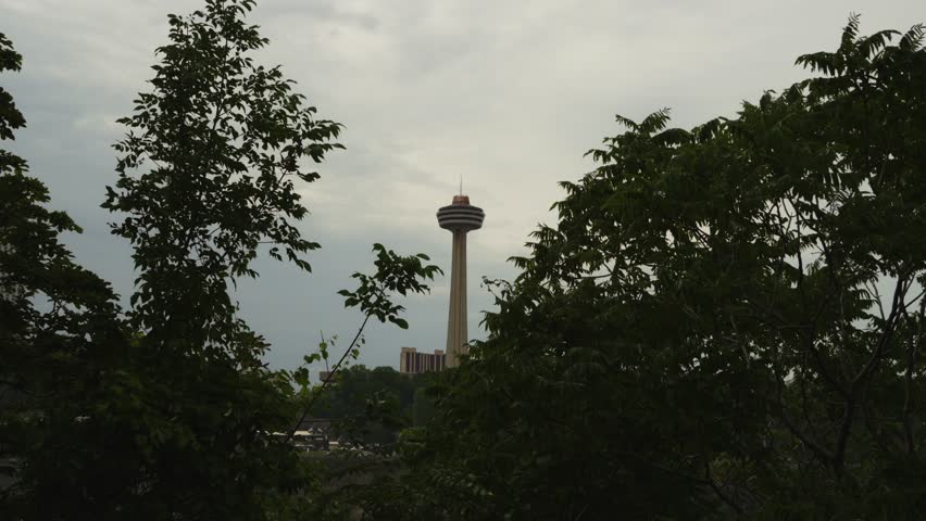 Dramatic shot of the Skylon Tower rising above the trees on an overcast day near Niagara Falls, Canada.