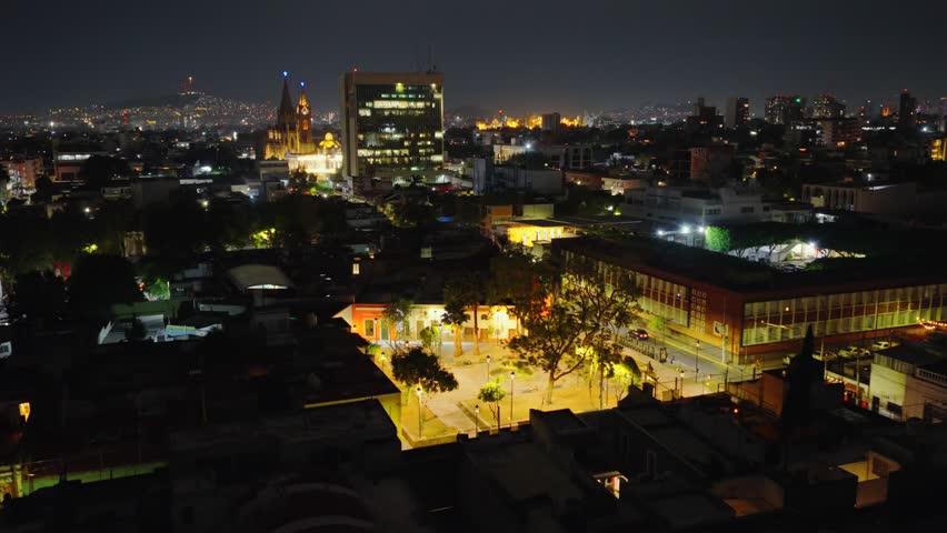 Estancia Garden At Night With General Rectory Building Of The University Of Guadalajara And Expiatorio Temple In Mexico - Drone Shot