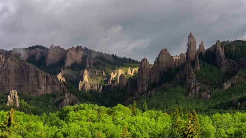 Timelapse, Clouds and Shadows Moving Above Scenic Rock Formations and Green Forest. Crested Butte, Colorado USA