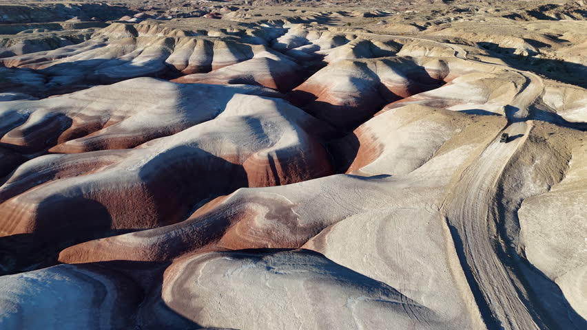 Drone Shot of ATV Vehicle on Desert Road Between Sandstone Bentonite Hills, Utah USA