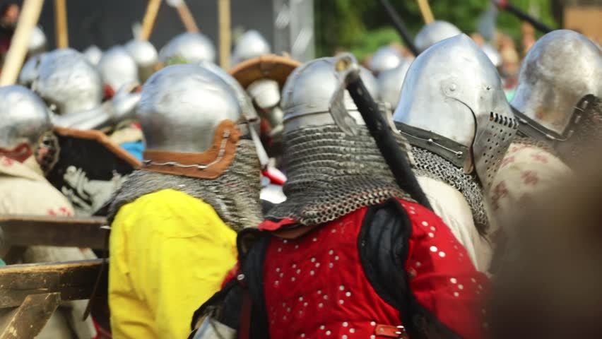 Group of medieval warriors posing together, dressed in armor and helmets.