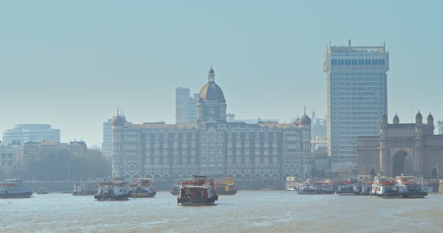 Mumbai, India. Many Boats with Tourists floating on the Arabian Sea. Tourists boats floating near Taj Mahal Palace hotel and Gateway of India. Cityscape skyline of Mumbai. Erected to commemorate the