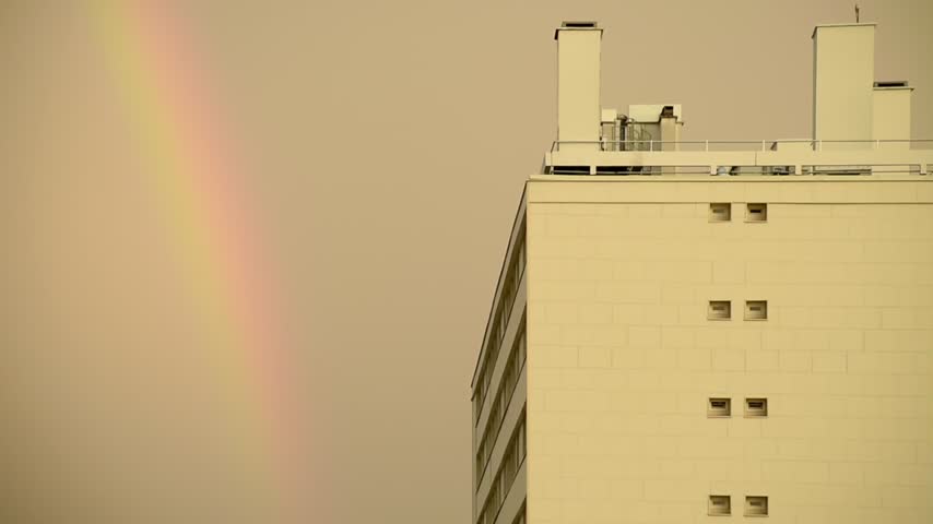 A bright multicolored rainbow that appeared after a very heavy rain in Paris on a summer day. The theme of changing weather, climate and the beauty of nature. HD high quality footage.