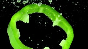Sliced Green Pepper. Green pepper slices fall on the water line on a black background. Slow Motion - Powered by Shutterstock - Get 15% off with code: PIKWIZARD15