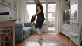 An active senior woman gets ready for her fitness training in the living room. She puts on sportswear and ties the laces on her sneakers, motivated for a run, walk, or workout. - Powered by Shutterstock - Get 15% off with code: PIKWIZARD15