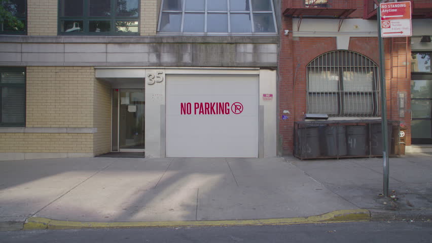 Handheld shot of a no parking sign in Brooklyn. Shot on a summer morning in Brooklyn.