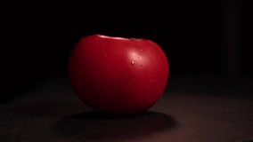 Fresh tomato rotating on black surface, covered with water droplets - Powered by Shutterstock - Get 15% off with code: PIKWIZARD15