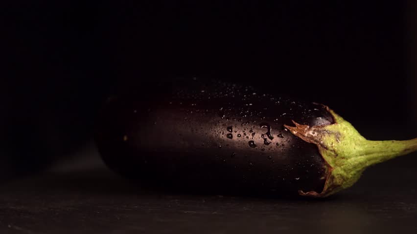 Wet eggplant rotating on black background