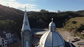 Aerial drone view soaring above the neoclassical domes and golden crosses of St. Peter of Alcantara Parish church in São Pedro de Alcântara, Santa Catarina, Southern Brazil. Serene blue sky backdrop - Powered by Shutterstock - Get 15% off with code: PIKWIZARD15
