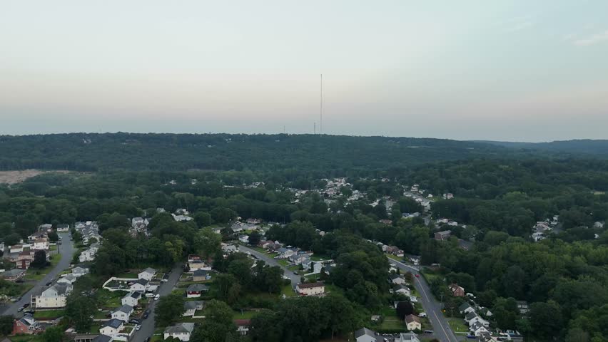 Aerial footage of South Main Street and the Naugatuck River in Waterbury, CT. Urban roads meet flowing water, capturing city life, bridges, and natural elements in a vibrant Connecticut setting.