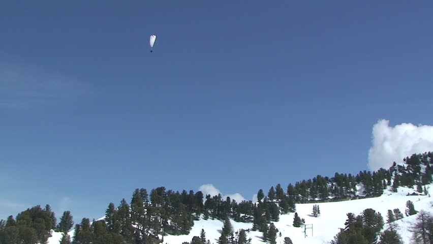 Paraglider flies high in the sky