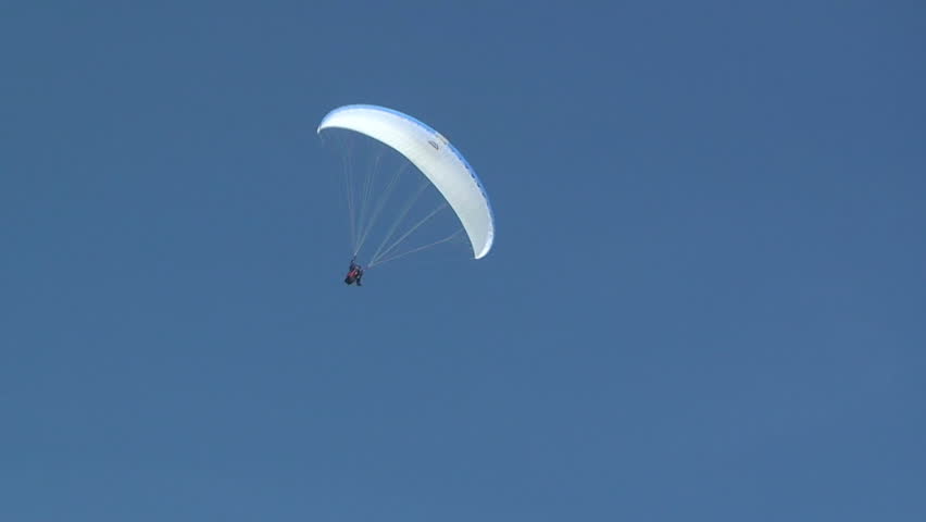 Paraglider soars in the clear blue sky