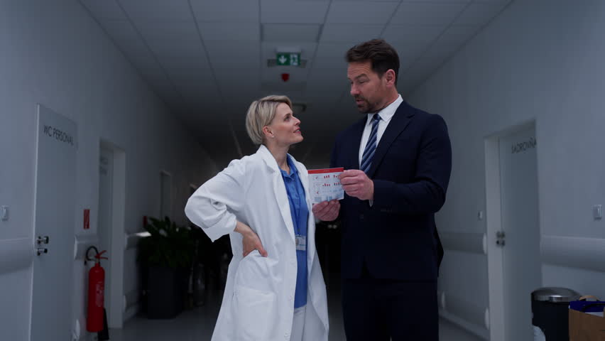Pharmaceutical sales representative introducing new medication to female doctor.