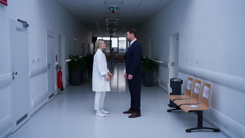 Doctor meeting pharmaceutical representative and shaking his hand, clinical setting.