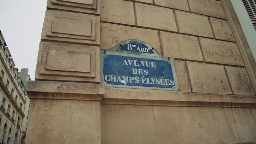 Paris, France -- October 10, 2024. Paris, France -- October 10, 2024. Close-up of traditional Parisian street sign for Champs-Élysées, mounted on a beige stone building