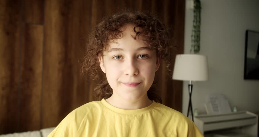 Close-up portrait of a child eating a ren apple. The camera focuses first on the child's face, and then on the hands with the apple.