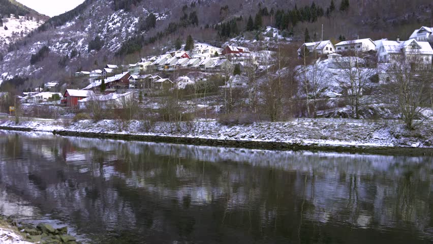 Small harbor with boats and snowy hillside houses Norway