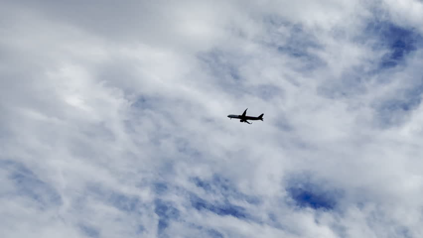 Silhouette of an airplane flying in the sky in slow motion