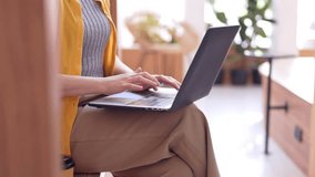 Adult Asian woman focused on her laptop keyboard in a bright contemporary cafe ideal for remote work productivity and online tasks - Powered by Shutterstock - Get 15% off with code: PIKWIZARD15